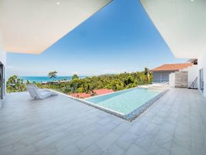 a house with a swimming pool and a villa at Villa Maviela Sea View 2 Bdr in Koh Samui