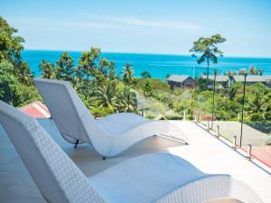un par de sillas blancas sentadas en un balcón con vistas al océano en Villa Maviela Sea View 2 Bdr, en Koh Samui 