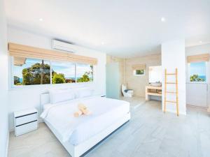 a bedroom with a white bed with a teddy bear on it at Villa Maviela Sea View 2 Bdr in Koh Samui  +22 photos