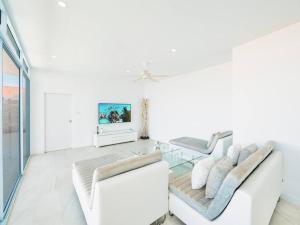 a living room with two white couches and a tv at Villa Maviela Sea View 2 Bdr in Koh Samui