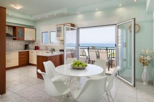 a kitchen and dining room with a table and chairs at White&Blue luxury suites in Ialysos