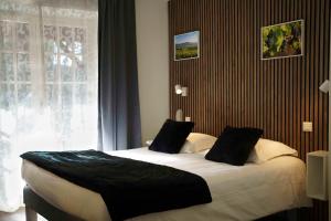 - une chambre avec un grand lit et une fenêtre dans l'établissement Hôtel Restaurant Le Moulin de Saint Verand, à Saint-Vérand