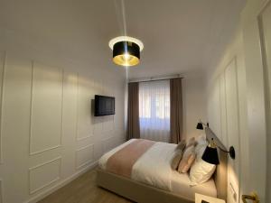 a bedroom with a bed and a tv on a wall at Central Spacious Apartment with Balcony - Alba Carolina in Alba Iulia
