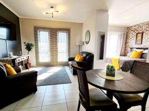 a living room with a table and a room with a bed at Luxury Lowveld Apartment in Nelspruit