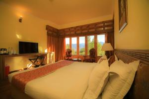 ein Hotelzimmer mit einem Bett und einem Fenster in der Unterkunft The Druk Ladakh in Leh