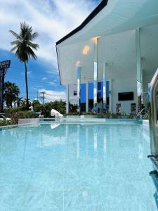 una gran piscina de agua azul frente a un edificio en Moose Hotel Chiangmai, en Chiang Mai