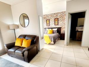 a bedroom with a bed and a chair and a mirror at Luxury Lowveld Apartment in Nelspruit