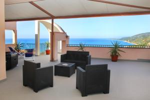 Un balcón con sillas y vistas al océano. en Attico vista mare con terrazza e spa riscaldata, en Santo Stefano di Camastra