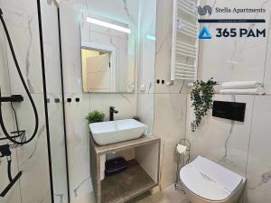 bagno bianco con lavandino e servizi igienici di Apartament ETNO LOFT 10 - 365PAM a Ustronie Morskie