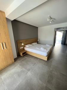 a bedroom with a large bed with a wooden headboard at ISALOS GERAKiNi in Yerakiní