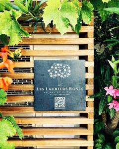 una señal para las casas de los luzern con flores en Les Lauriers Roses - Maison d'Hôtes, en Barjac
