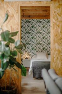 - une chambre avec un lit dans une pièce dotée d'une plante dans l'établissement Grand loft avec Jacuzzi et Home Cinema, à Saint-Brieuc