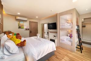 a bedroom with two teddy bears laying on a bed at Moose Hotel Chiangmai in Chiang Mai