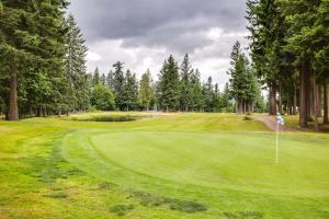 a golf course with a green field and trees at Newly Built Maple Valley Vacation Rental with Patio! in Maple Valley