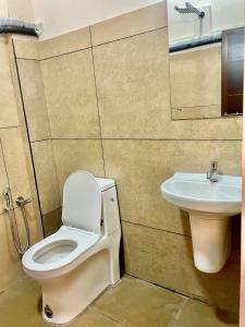 łazienka z toaletą i umywalką w obiekcie Reach Residency w mieście Koczin