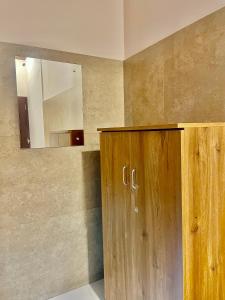 a bathroom with a wooden cabinet and a mirror at Reach Residency in Cochin