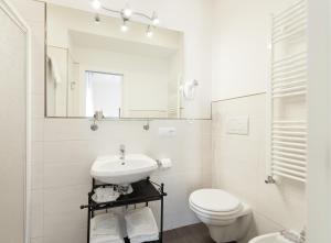 ein weißes Bad mit einem Waschbecken und einem WC in der Unterkunft Alba Romana in Rom