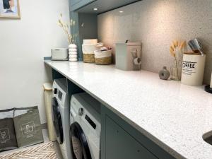 a kitchen with a washing machine under a counter at Bob W Bonn Zentrum in Bonn +42 photos