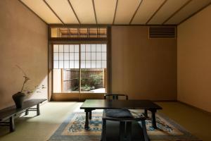 a room with a table and chairs and a window at Yasakahan in Kyoto