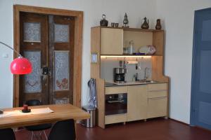 uma pequena cozinha com uma mesa e um armário de madeira em Schloss Gröbitz em Gröbitz