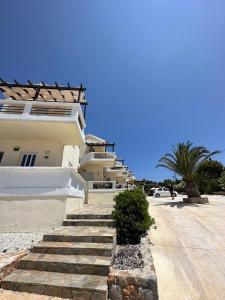 a building with stairs in front of a street at Tersanas Beach Lodges in Tersanas