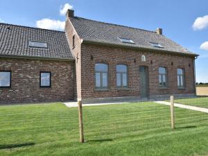 a brick building with windows on a grass field at Spacious Holiday Home with Pond in Poperinge in Roesbrugge-Haringe