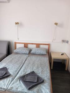 a bedroom with a bed with two towels on it at Cuki Apartmanok in Si&oacute;fok