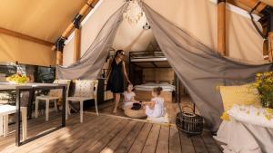 a woman and two girls sitting in a tent at Polidor Glamping Resort in Poreč