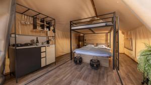 a bedroom with a bunk bed and a kitchen at Polidor Glamping Resort in Poreč