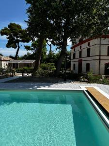 une piscine en face d'une maison avec un bâtiment dans l'établissement Villa Miramare, à Numana