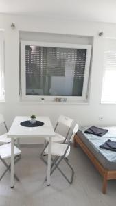 シオーフォクにあるCuki Apartmanokの白いダイニングルーム(テーブル、椅子付)
