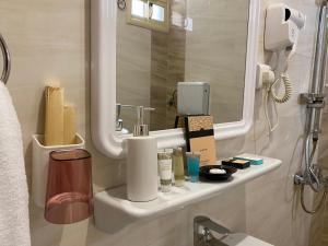 فندق وايت هافن في Sūq al Aḩad: حمام مع حوض ومرآة