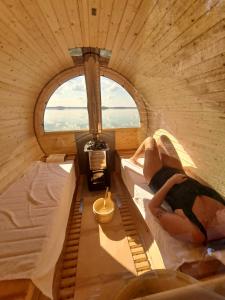 two women laying on beds in a room with a window at Domek nad jeziorem Dobskim - Fuleda 5 in Fuleda