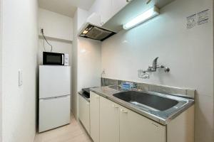 a kitchen with a sink and a refrigerator at Osaka house honkan in Osaka