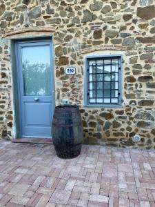a building with a door and a barrel in front of it at Calema Country House Vinci in Vinci