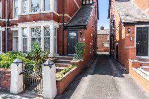 an empty alley in a brick house with a black door at St David's - Stylish 2 bed apartment, free parking, close to beach in Lytham St Annes