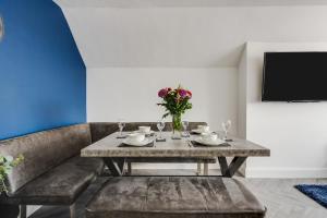 comedor con mesa y TV en St David's - Stylish 2 bed apartment, free parking, close to beach en Lytham St Annes
