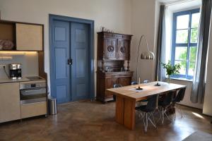 a kitchen with a wooden table and a blue door at Schloss Gröbitz in Gröbitz