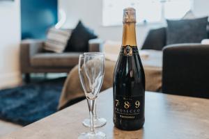 una botella de champán y una copa de vino en una mesa en St David's - Stylish 2 bed apartment, free parking, close to beach en Lytham St Annes