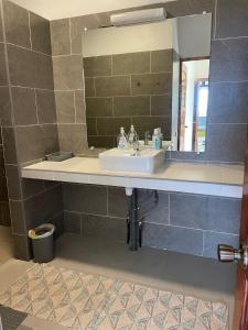 a bathroom with a sink and a mirror at Villa Ura in Uturoa