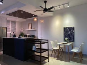 a kitchen with a ceiling fan and a table and chairs at The Cotton Bleu Homestay in Kuala Terengganu