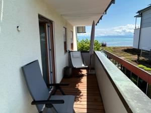 a balcony with chairs and a view of the ocean at Strandhaus Eberle in Immenstaad am Bodensee
