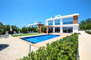 a villa with a swimming pool in front of a building at Coral Elite Residences in Coral Bay