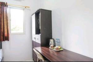 a kitchen with a wooden counter top in a room at PAS Residence Sam Ratulangi Airport Mitra RedDoorz in Mapanget