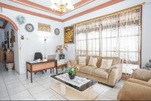 - un salon avec un canapé et une table dans l'établissement PAS Residence Sam Ratulangi Airport Mitra RedDoorz, à Mapanget