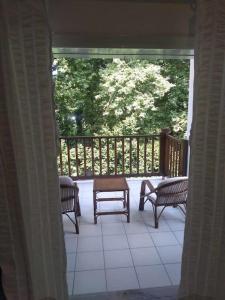 an open porch with chairs and a table on a deck at Serene appartment at St. Ioannis in Agios Ioannis Pelio