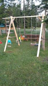 a swing set in a yard with a bench at Eco Village Podgora Household Kaljevic in Žabljak