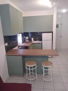 a kitchen with a counter and two stools in it at Serene appartment at St. Ioannis in Agios Ioannis Pelio