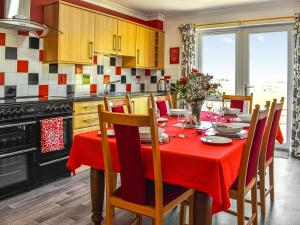 a kitchen with a table with a red table cloth at Little Glengyre Farm in Kirkcolm