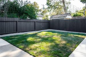 a backyard with a fence and green grass at Wren Guest House in Concord
